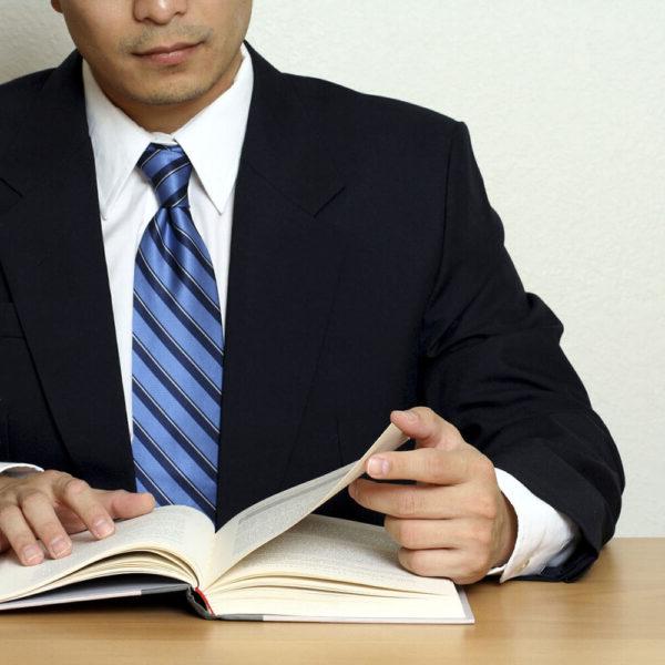 A man in a suit and tie reading a book